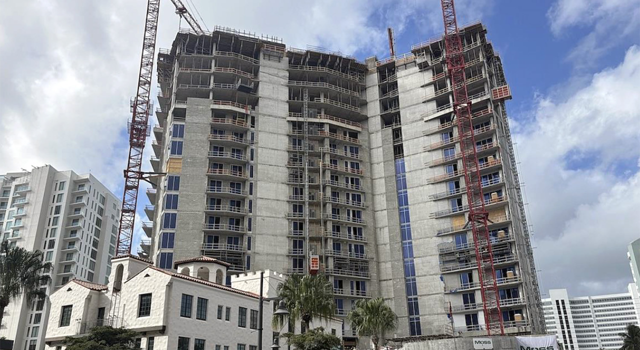 High-rise condominium building under construction with cranes and scaffolding